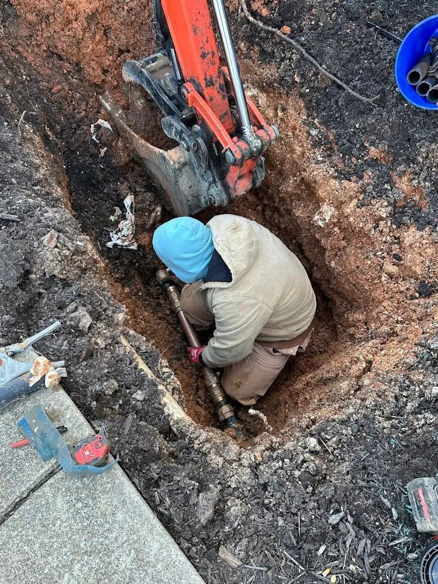 Excavator-assisted underground pipe repair in a deep trench